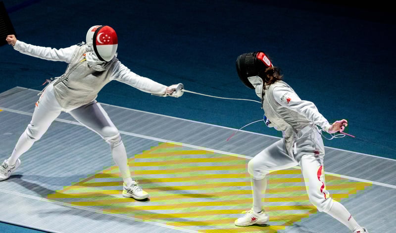 Amita Berthier (left) stretches to strike her Chinese opponent in the women’s team foil contest. (Photo: SNOC/ Kelly Wong)