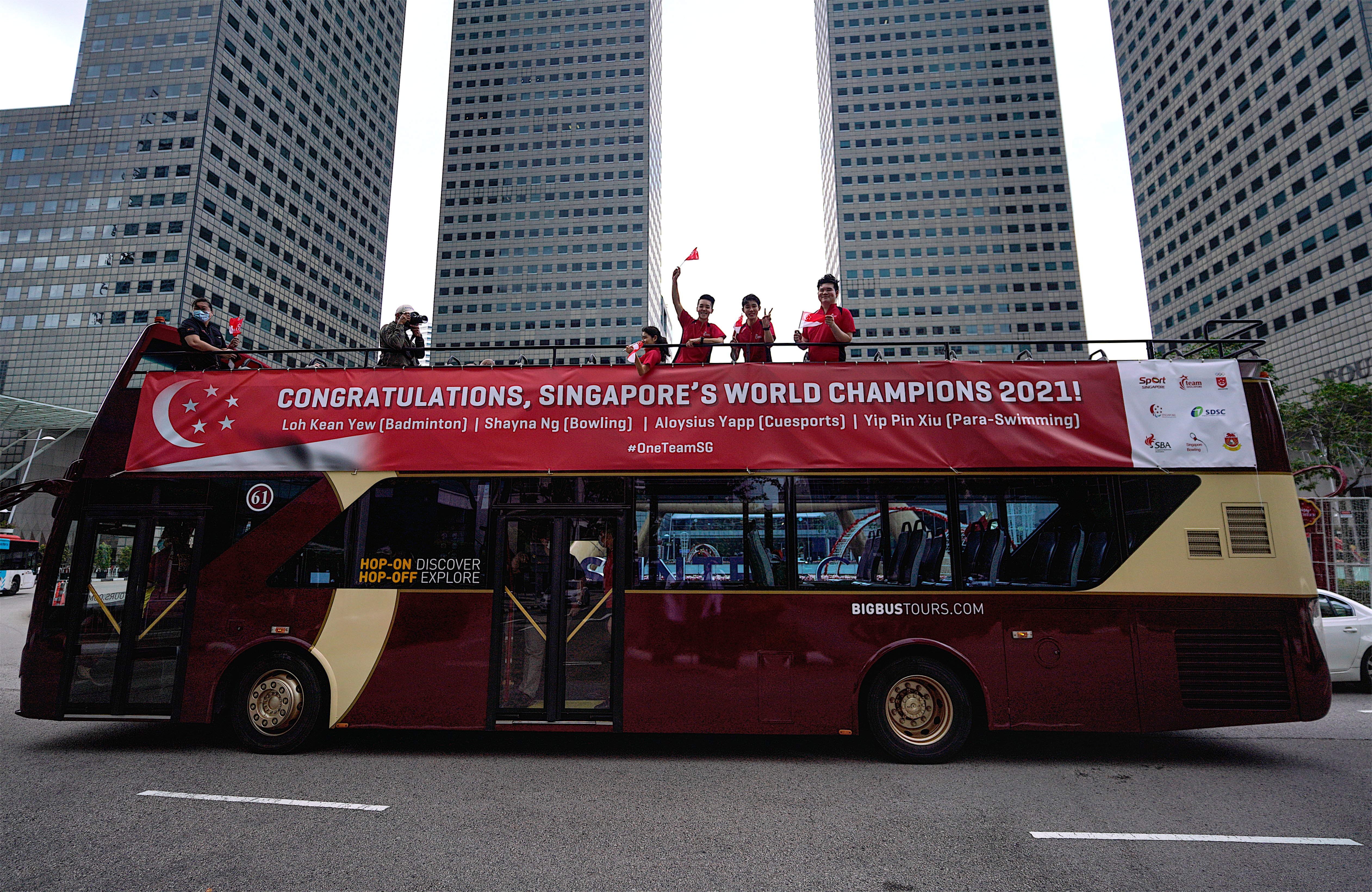 Athletes greeting crowd from open-top bus-1