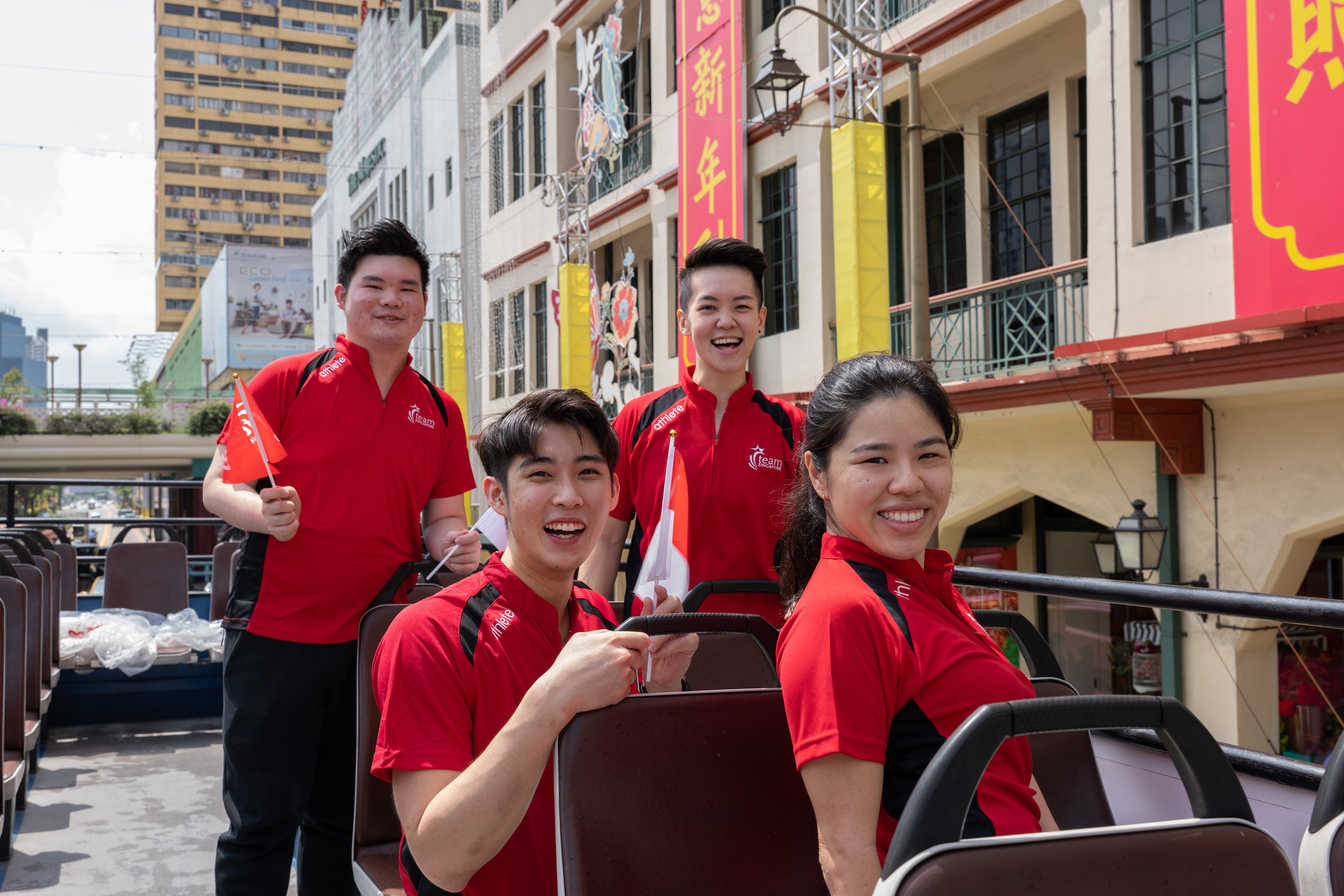 Athletes on the open-top bus passing by Chinatown
