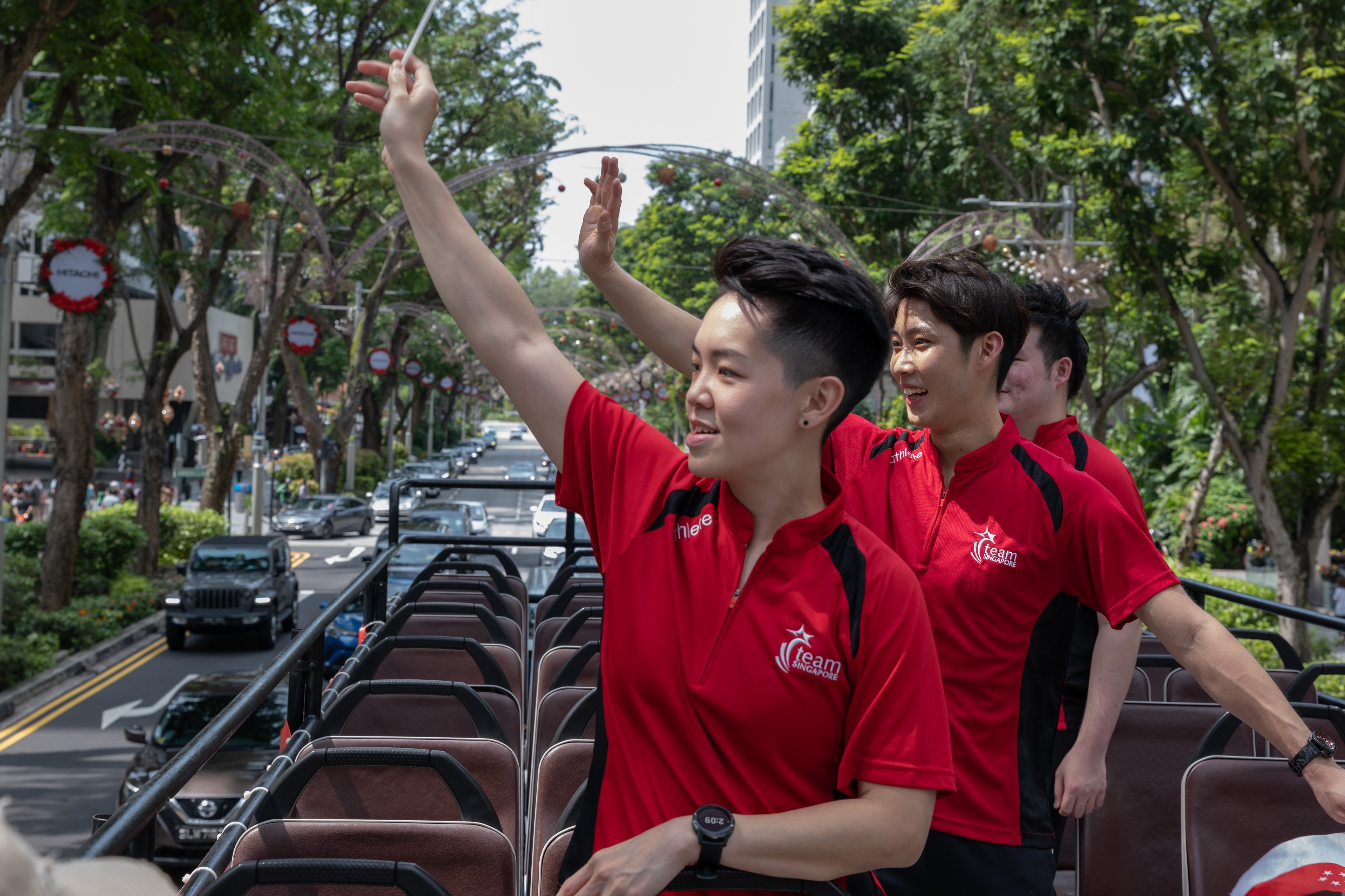 Athletes waving to crowd along orchard road