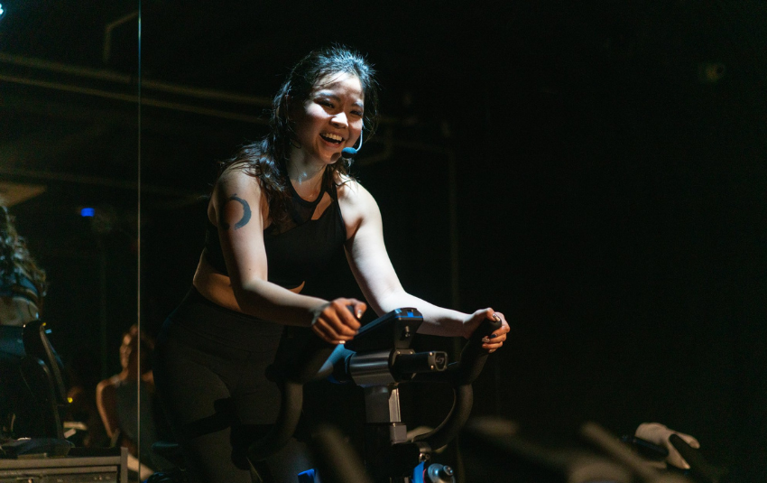 Axiom female instructor during a spin class