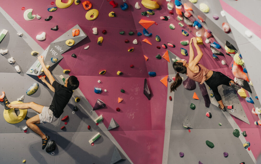 Man and woman scaling bouldering wall at Boulder Movement