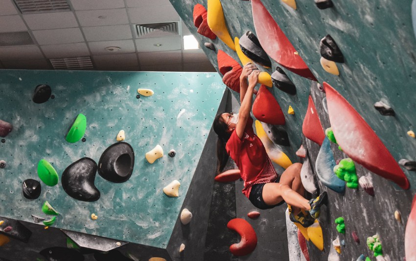 Girl in red doing bouldering at Boulder World