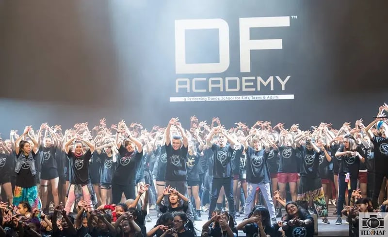 Group of dancers showing hand sign after performance
