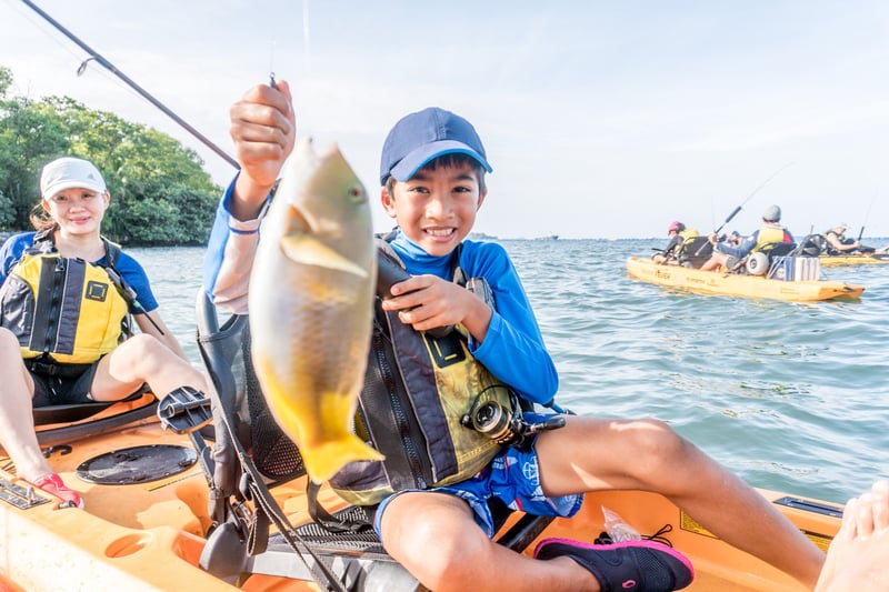Mother with her son showing the fish he caught while kayaking