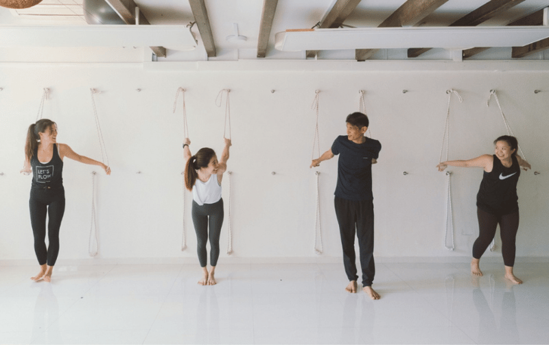 Practising yoga with yoga bands tied to the wall