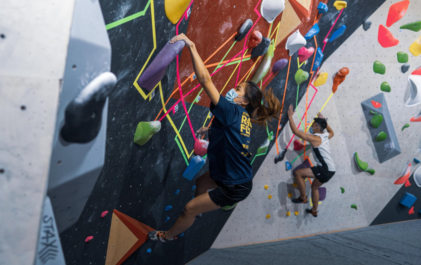 2 women doing bouldering on colourful wall at Lighthouse Climbing