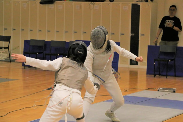 ACJC's Lia Swee (Right) faced off against Victoria Chew (Raffles Institution) in the Semi-finals of the Foil event. Photo Credit : Team Nila Content Producer, Anbumani Arivalagan.