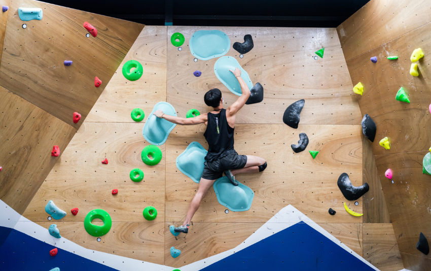 Man scaling bouldering wall at Origin Boulder