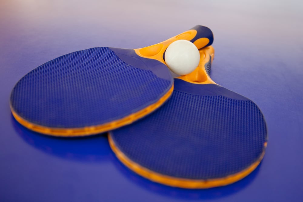 Ping pong set with two blue rackets and a white ball