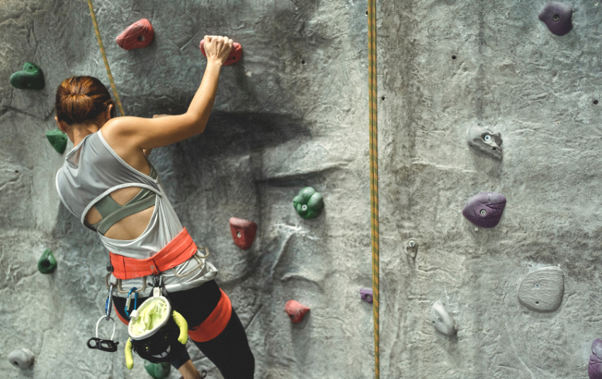 Woman doing rock climbing at outdoor wall