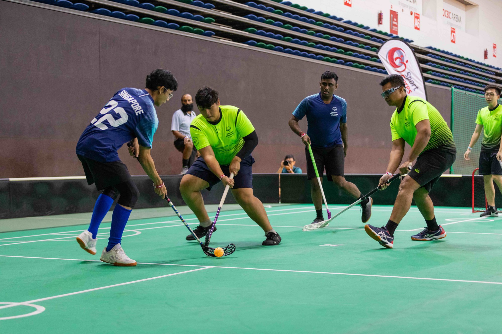 Photo of players in two different team jerseys competing in a floorball match
