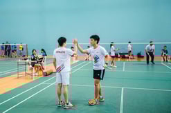 Photo of an athlete with special needs high five his unified partner without disability at the end of a match during Play Inclusive