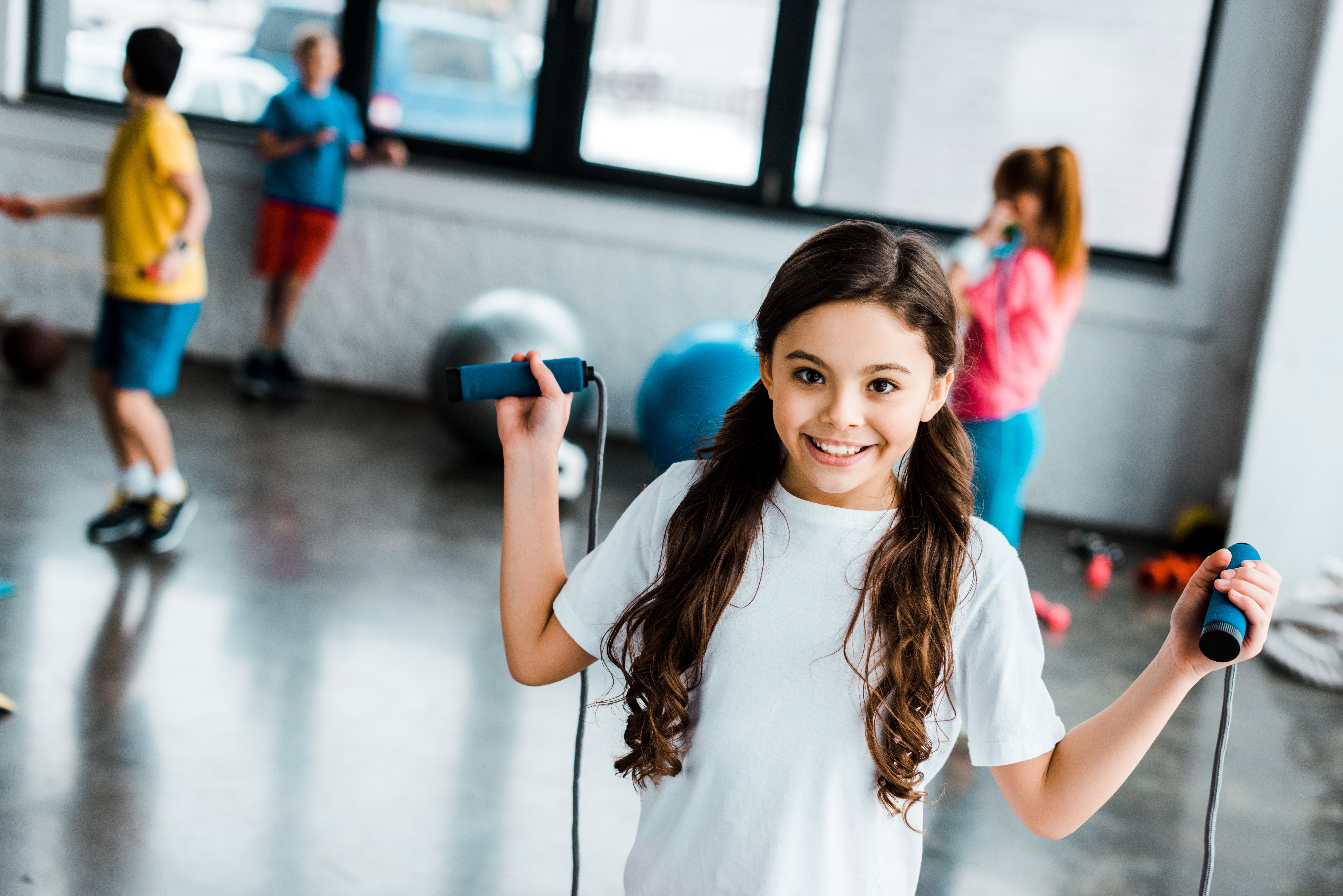 Group Of Playful Children Skipping Together With Jumping Rope On