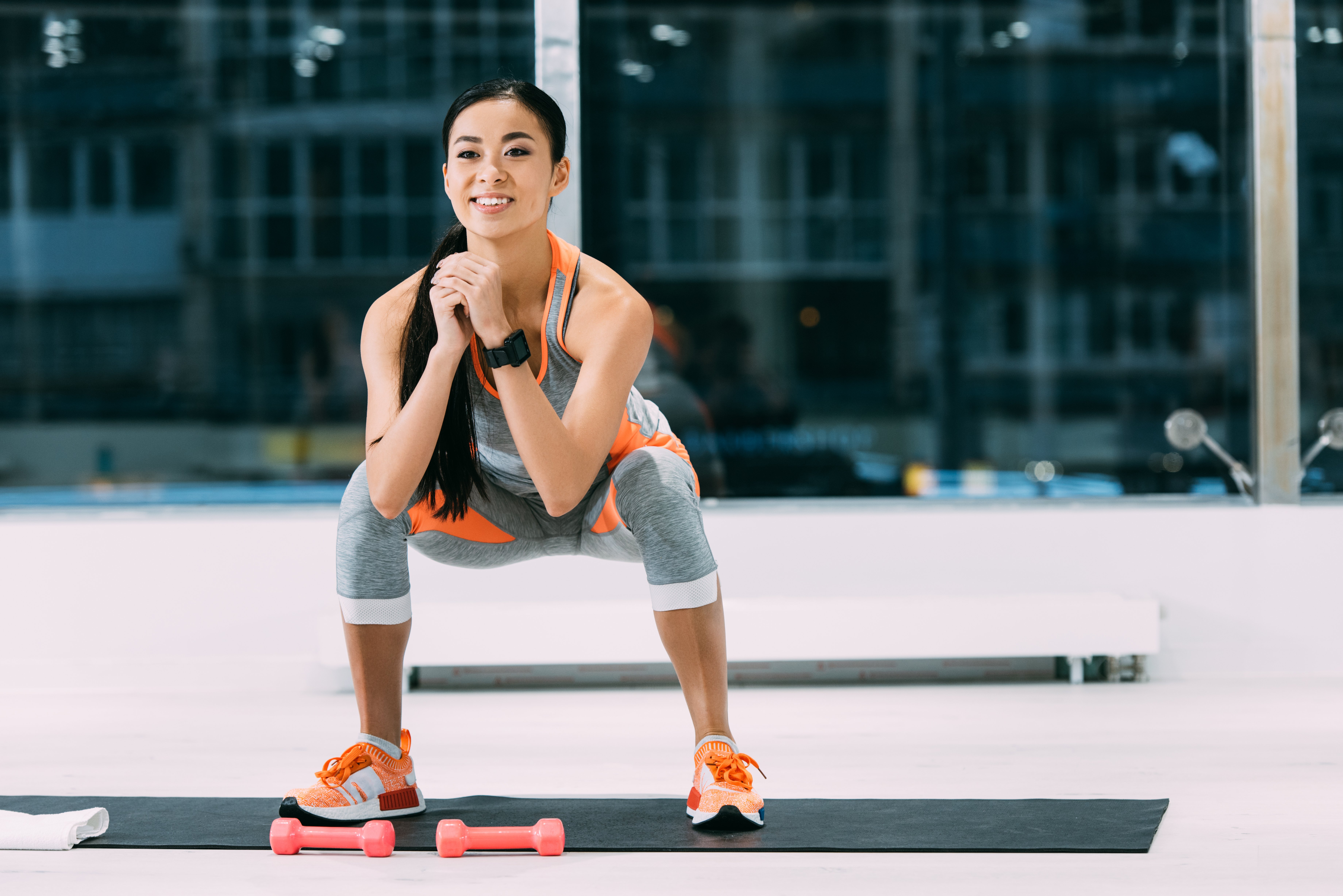 smiling-asian-girl-doing-squats-on-fitness-mat-at-2022-10-20-17-05-06-utc