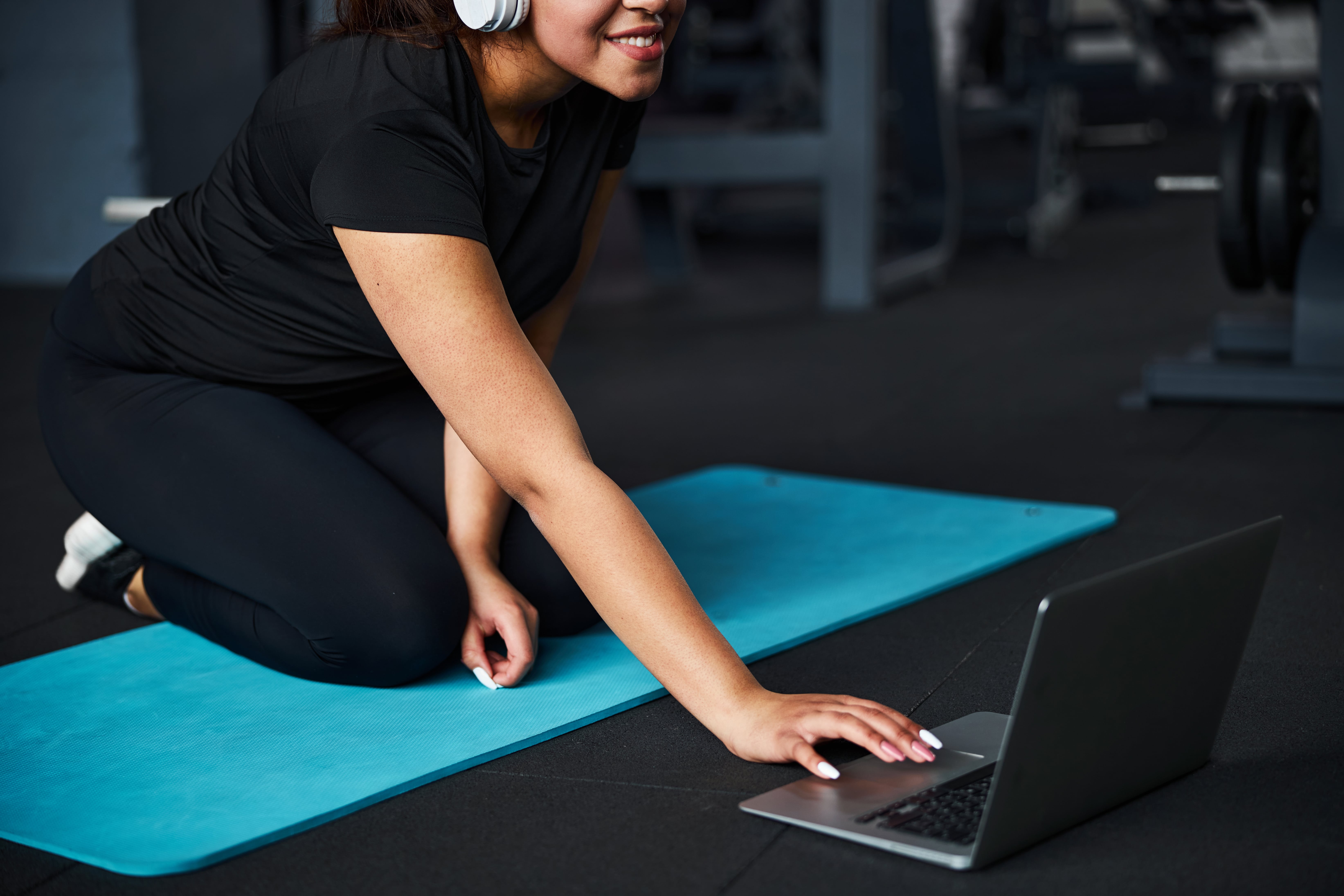 serene-female-exercising-in-gym-online-with-gadget-2021-09-03-07-04-04-utc-min